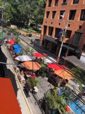 an overhead view of a street with tables with umbrellas at Apartamento zona rosa El poblado 202 in Medellín