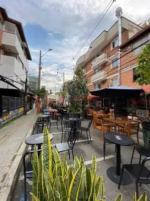 an outdoor cafe with tables and chairs and tables and chairs at Apartamento zona rosa El poblado 202 in Medellín