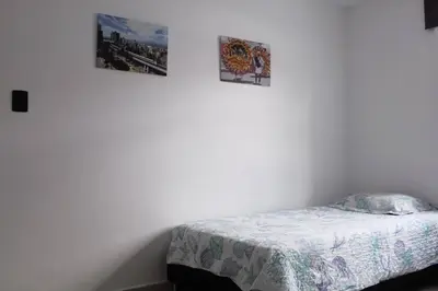 a bedroom with a bed and three pictures on the wall at Apartamento zona rosa El poblado 202 in Medellín
