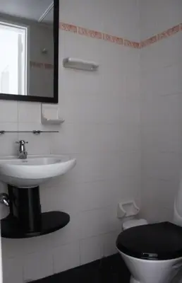 a bathroom with a sink and a toilet and a mirror at Apartamento zona rosa El poblado 202 in Medellín