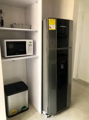 a refrigerator in a kitchen next to a microwave at Apartamento zona rosa El poblado 202 in Medellín