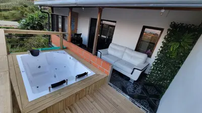a jacuzzi tub on a balcony with a couch at EDYMA Cabaña con JACUZZI in Guatapé