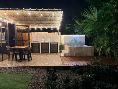 a patio at night with a table and a grill at Cabaña in Sopetran