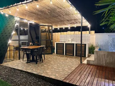 a patio with a table and a kitchen with lights at Cabaña in Sopetran