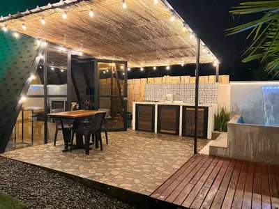 a patio with a table and a kitchen with lights at Cabaña in Sopetran
