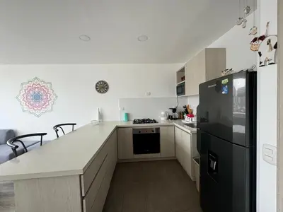 a kitchen with a black refrigerator and white cabinets at Barcelona in Manizales