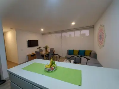 a room with a table with a bowl of fruit on it at Barcelona in Manizales