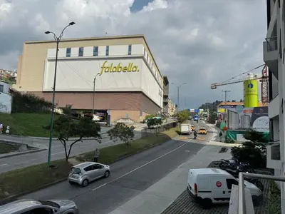 a street with a building and cars parked on the road at Barcelona in Manizales