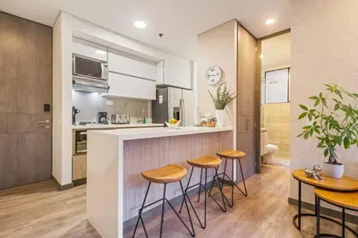 a kitchen with a counter and stools in a kitchen at Ideal place in el Poblado, Medellin in Medellín