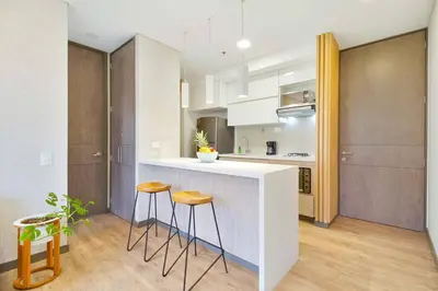 a kitchen with a white counter and stools in it at The perfect stay in Medellín - 904 in Medellín