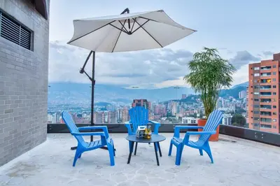 a patio with chairs and a table and an umbrella at The perfect stay in Medellín - 904 in Medellín