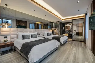 a hotel room with two beds and a bathroom at Tribeca Suites Medellin in Medellín