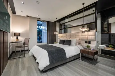 a bedroom with a large white bed and a desk at Tribeca Suites Medellin in Medellín