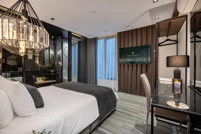 a bedroom with a bed and a desk and a chandelier at Tribeca Suites Medellin in Medellín