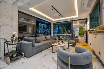 a living room with a couch and chairs at Tribeca Suites Medellin in Medellín