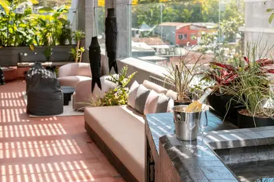 a patio with a couch and a table and plants at Primavera Luxury Apartments Medellin in Medellín
