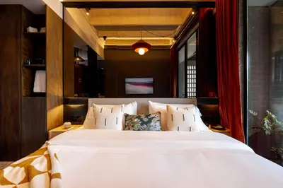 a bedroom with a large white bed and red curtains at Primavera Luxury Apartments Medellin in Medellín