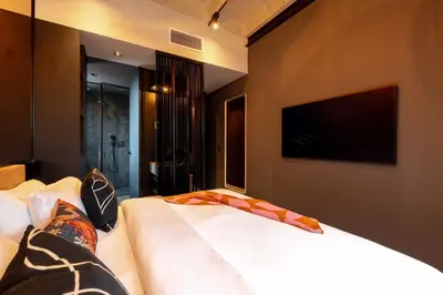 a bedroom with a bed with a tv on the wall at Primavera Luxury Apartments Medellin in Medellín