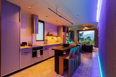 a kitchen with purple walls and a table and chairs at Primavera Luxury Apartments Medellin in Medellín