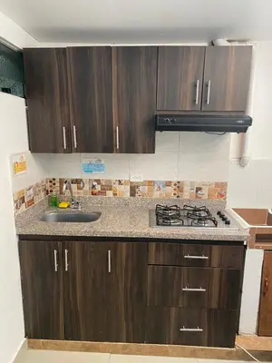 a kitchen with wooden cabinets and a sink at CASA ESTADIO MEDELLIN Apartamentos Turisticos renovados y modernos para Familias, Grupos o Delegaciones Deportivas - Sector Laureles-Estadio in Medellín