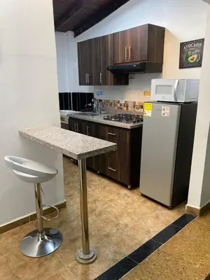 a kitchen with a counter and a refrigerator at CASA ESTADIO MEDELLIN Apartamentos Turisticos renovados y modernos para Familias, Grupos o Delegaciones Deportivas - Sector Laureles-Estadio in Medellín