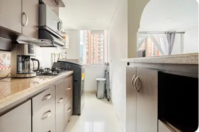 a kitchen with white cabinets and a black appliance at Luxurious Stay in Bello