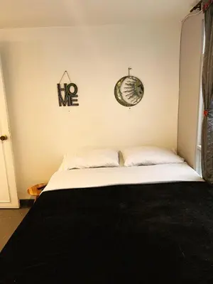 a bedroom with a bed and a clock on the wall at Amplio, Cómodo y tranquilo Apto cerca a Milan y Cable Plaza in Manizales