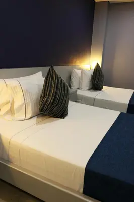two beds in a hotel room with pillows on them at Hotel Lleras 10 in Medellín