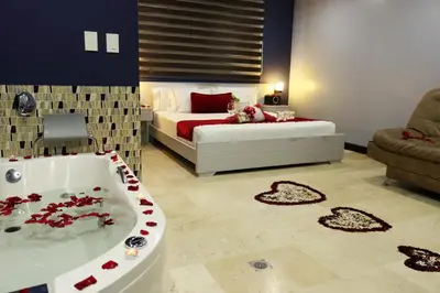 a bedroom with a bed and a bath tub in a room at Hotel Lleras 10 in Medellín