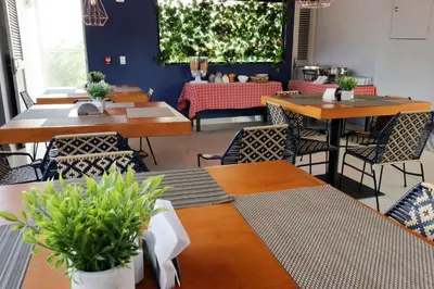 a restaurant with wooden tables and chairs with plants at Hotel Lleras 10 in Medellín