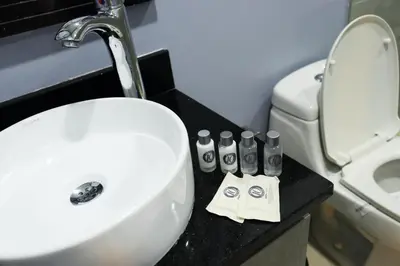 a bathroom with a white sink and a toilet at Hotel Lleras 10 in Medellín