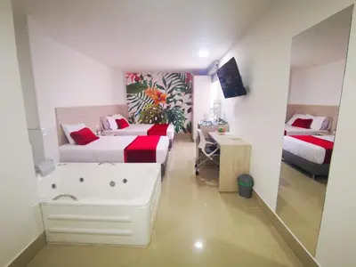 a bedroom with a tub and a bed and a desk at Hotel Lleras Express in Medellín