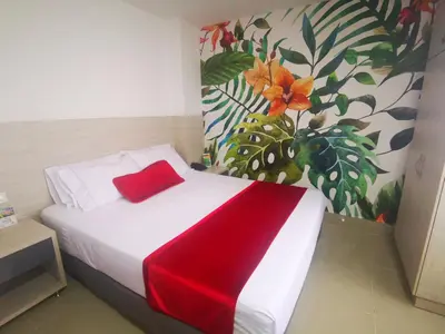 a bedroom with a bed with a red blanket on it at Hotel Lleras Express in Medellín
