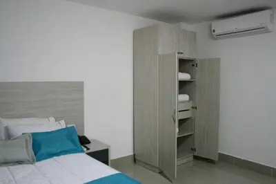a bedroom with a bed and a book shelf at Hotel Lleras Express in Medellín