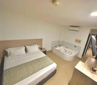 a bedroom with a bed and a bath tub at Hotel Lleras Express in Medellín