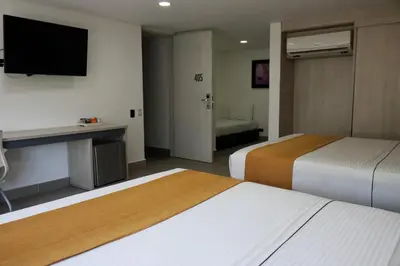 a hotel room with two beds and a flat screen tv at Hotel Loup in Medellín