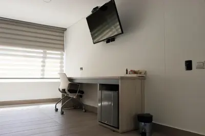 an office with a desk and a tv on the wall at Hotel Loup in Medellín