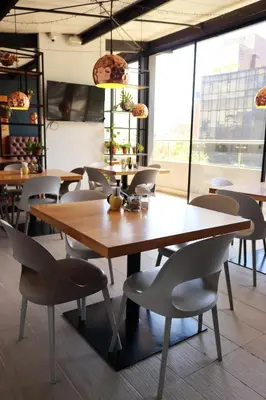 a dining room with tables and chairs and a large window at Hotel Loup in Medellín