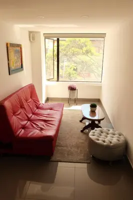 a living room with a red couch and a table at Hotel Loup in Medellín