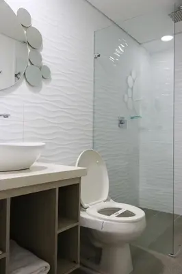 a bathroom with a toilet and a glass shower at Hotel Loup in Medellín