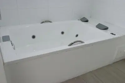a white bath tub with two sinks in a bathroom at Hotel Loup in Medellín