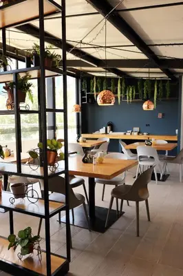 a restaurant with wooden tables and chairs and plants at Hotel Loup in Medellín
