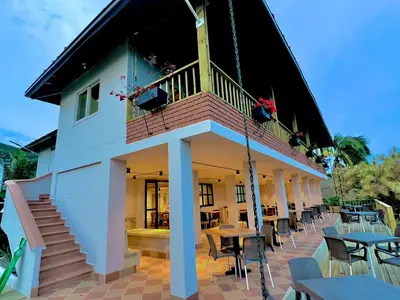 a building with a balcony and tables and chairs at Hotel Monteverde Campestre in Concordia