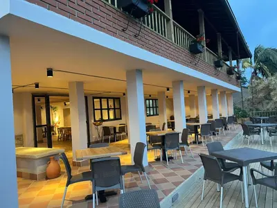 a patio with tables and chairs and tables and a building at Hotel Monteverde Campestre in Concordia