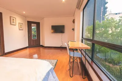 a bedroom with a bed and a desk and a window at Habitación de Comfort total en el Poblado - A2 in Medellín