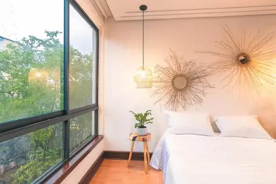 a bedroom with a bed and a large window at Comoda habitacion baño compartido en el Poblado-A4 in Medellín