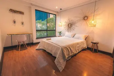 a bedroom with a bed and a large window at Comoda habitacion baño compartido en el Poblado-A4 in Medellín