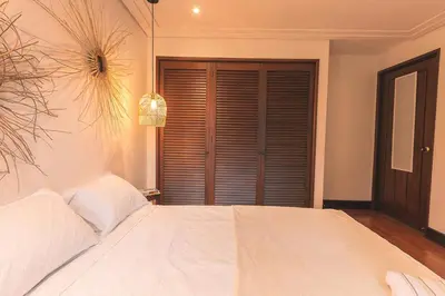 a bedroom with a large white bed with a window at Comoda habitacion baño compartido en el Poblado-A4 in Medellín