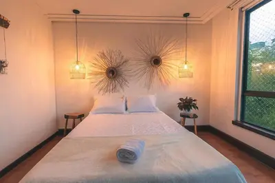 a bedroom with a large bed with two pillows at Bello alojamiento baño compartido en el Poblado-A5 in Medellín