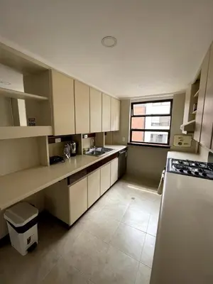 a large kitchen with white cabinets and a window at Bello alojamiento baño compartido en el Poblado-A5 in Medellín